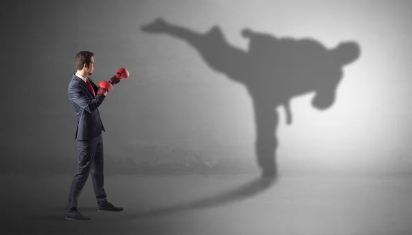 Young businessman fighting with his shadow — Stock Photo, Image