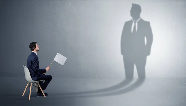 Businessman staying and offering stuffs to a huge businessman shadow — Stock Photo, Image