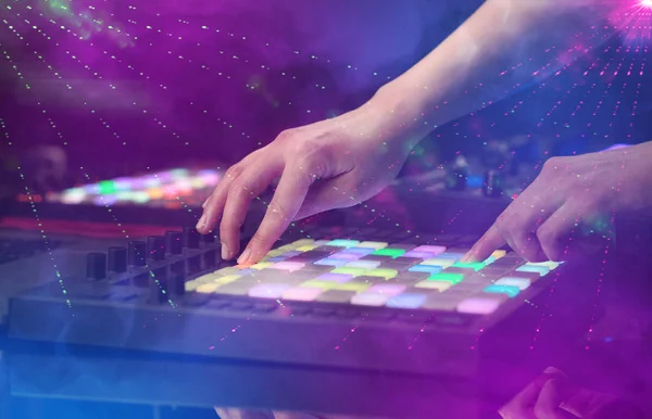 Mezcla de música a mano en el controlador dj con colores del club de fiesta alrededor — Foto de Stock