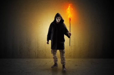 Boş bir alanda flambeau yanma ile yürüyen adam