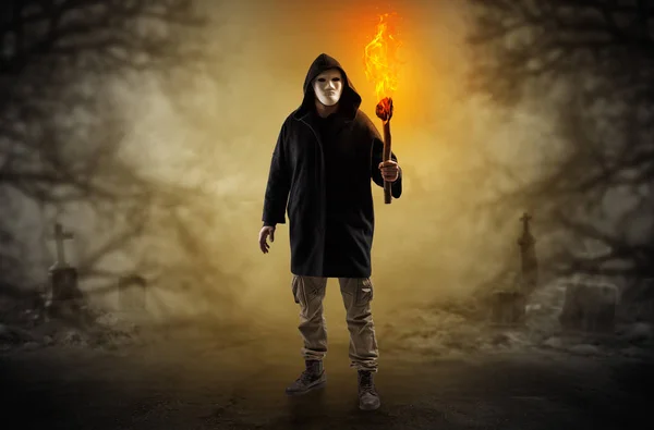 Mann kommt mit brennendem Flambeau aus einem Gebüsch — Stockfoto
