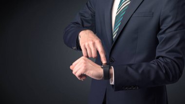 Smartwatch giyen takım elbiseli adam.