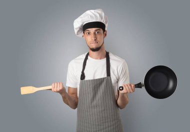 Genç aşçı portre ile mutfak aletleri ve boş duvar kağıdı sakallı 