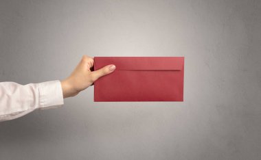 Zarf boş duvar arka plan ile tutan el