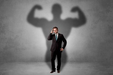 Businessman with muscular shade behind his back clipart