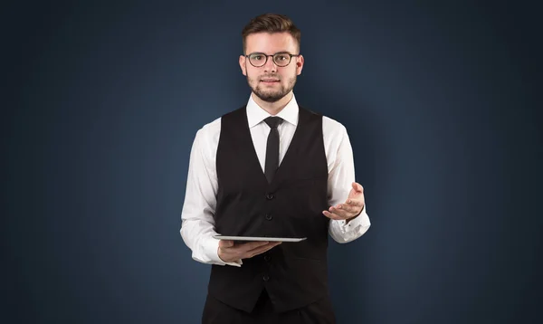 Empresario sosteniendo tableta con fondo oscuro — Foto de Stock