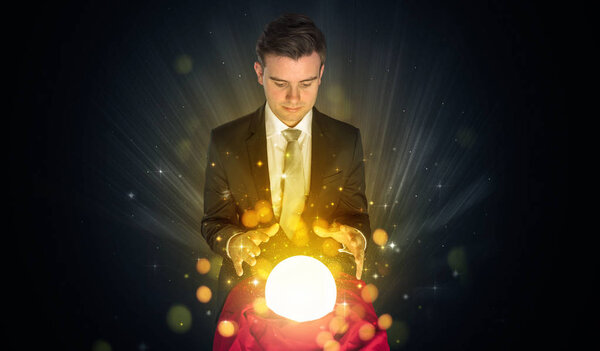Businessman  sitting with sparkling magic ball