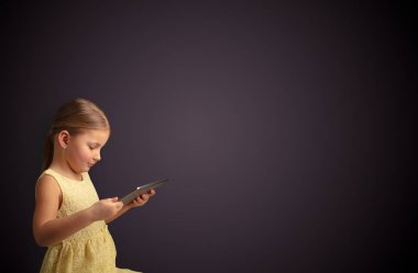 Tablet ile koyu arka plan kullanarak sevimli küçük kız