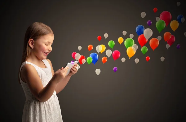Meisje bedrijf tablet met kleurrijke ballonnen rond — Stockfoto