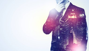 Düşünme ve gece gökdelen arka plan ile duran genç işadamı