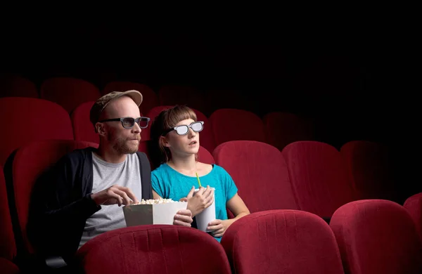 Jovem casal sentado no cinema vermelho — Fotografia de Stock