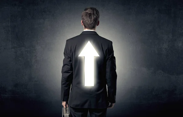 Young businessman standing with arrow on his back — Stock Photo, Image