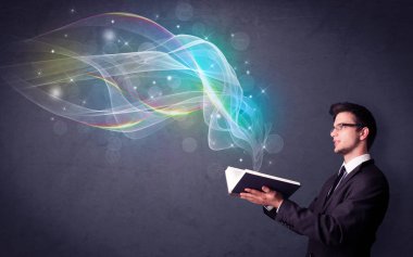 Gökkuşağı dalgalar dışarı uçan ile kitap tutan rahat genç adam