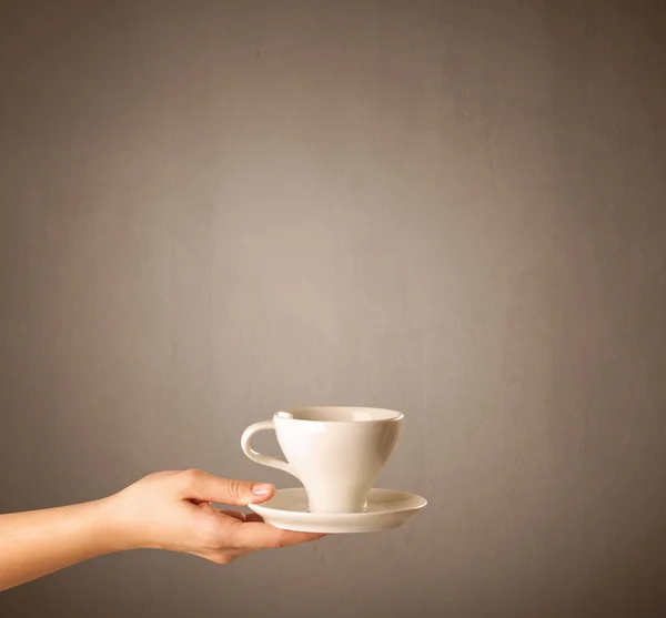 Vrouwelijke hand bedrijf koffie beker — Stockfoto
