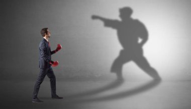 Young businessman fighting with his shadow clipart
