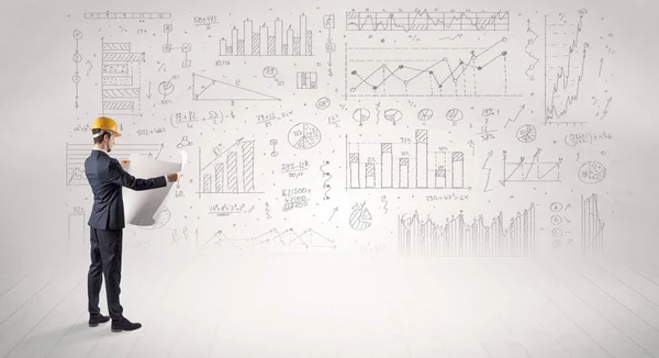 Ingenjören hålla en plan och stående med grafer, diagram och rapporter i bakgrunden — Stockfoto