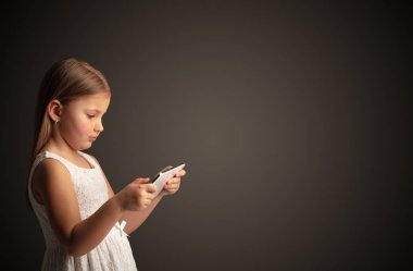 Tablet ile koyu arka plan kullanarak sevimli küçük kız