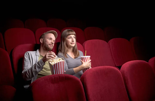 Young couple sitting at red movie theatre — Stock Photo, Image