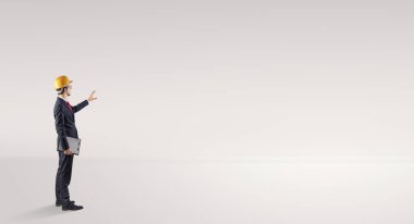 Boş bir alanda duran ve bir plan tutan mimar