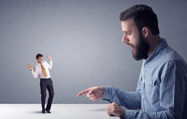 Joven hombre de negocios luchando con empresario en miniatura —  Fotos de Stock