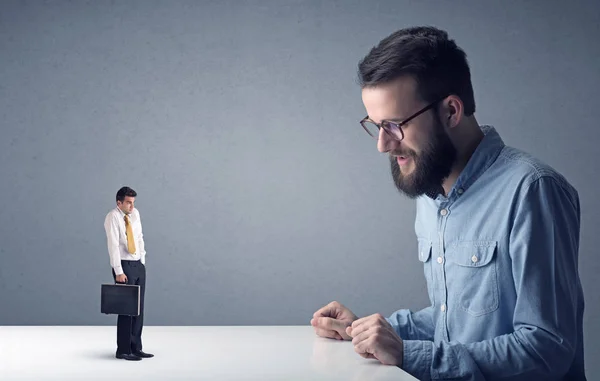 Joven hombre de negocios luchando con empresario en miniatura — Foto de Stock