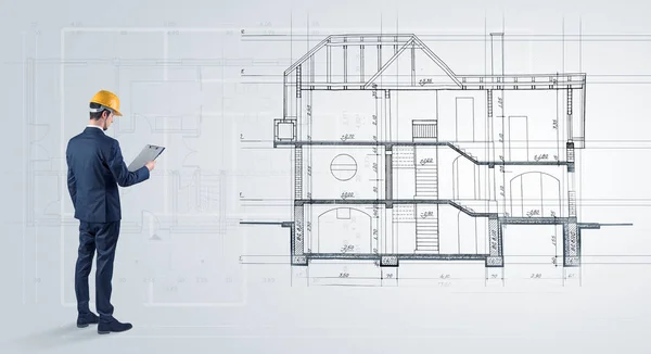 Architekt při pohledu na plán domu — Stock fotografie
