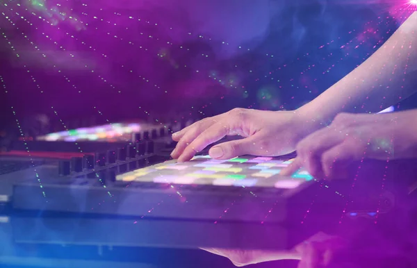 Hand blanda musik på MIDI-controller med party club färger runt — Stockfoto