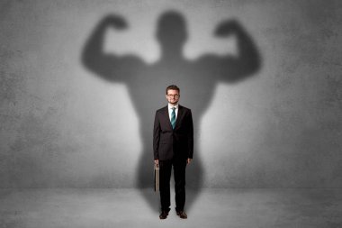 Businessman with muscular shade behind his back clipart