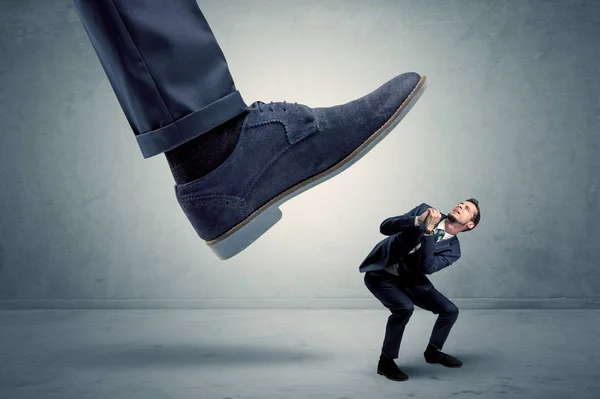 Angestellter wird von großem Schuh getreten — Stockfoto