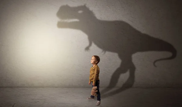 Dinosaurus skugga bakom söt pojke — Stockfoto