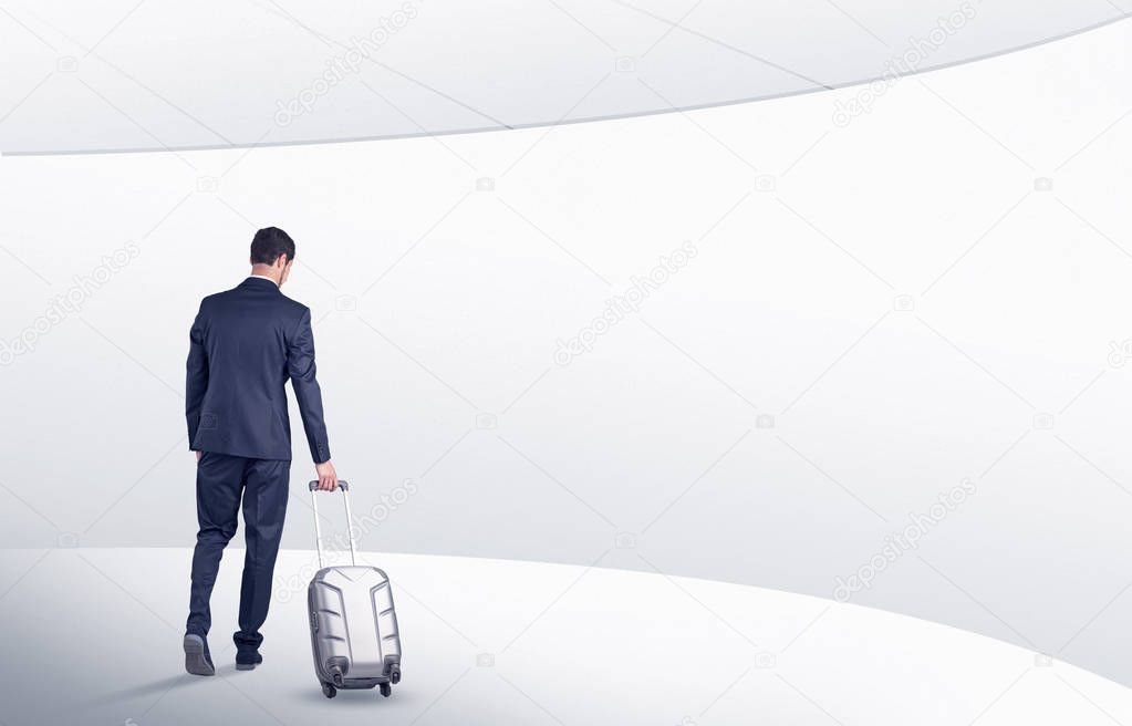 Businessman with suitcase walking in waiting room