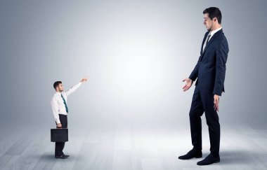 Dev bir işadamı için işaret eden küçük iş adamı