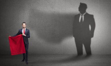 Boğa güreşçisi kavramı ve onun gölgesi arka planda ile işadamı