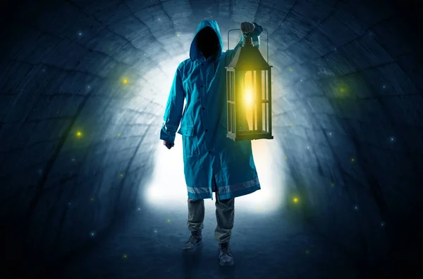 Man walking with lantern in a dark tunnel — Stock Photo, Image