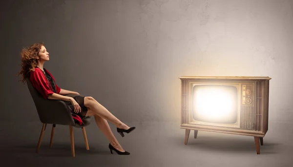 Young lady watching to a vintage television — Stock Photo, Image