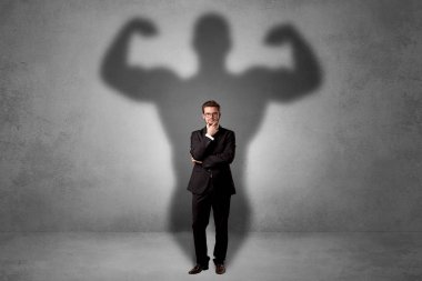 Businessman with muscular shade behind his back clipart