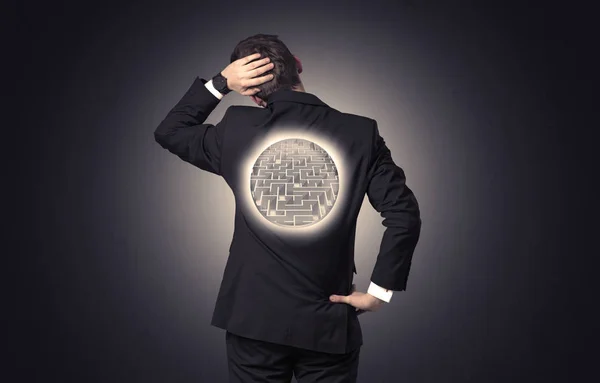 Businessman standing with maze on his back — Stock Photo, Image