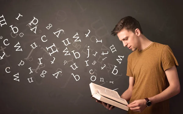 Young man holding book with letters — Stock Photo, Image
