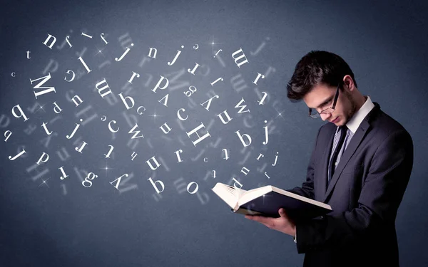 Jovem segurando livro com letras — Fotografia de Stock