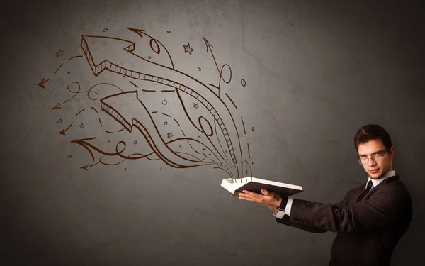 Young man holding book with arrows — Stock Photo, Image