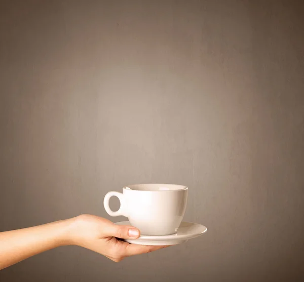 Vrouwelijke hand bedrijf koffie beker — Stockfoto