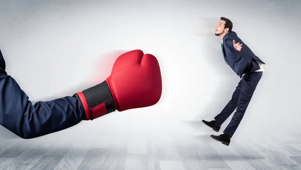 Red boxing glove knocks out little businessman — Stock Photo, Image