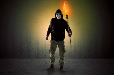 Boş bir alanda flambeau yanma ile yürüyen adam