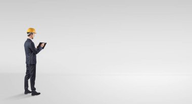 Boş bir alanda duran ve bir plan tutan mimar