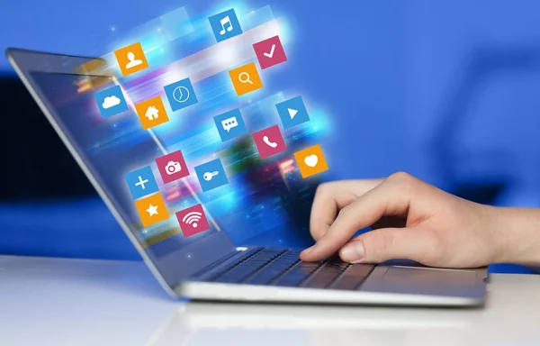 Hand laptop met kleurrijke toepassing pictogrammen en symbolen concept — Stockfoto