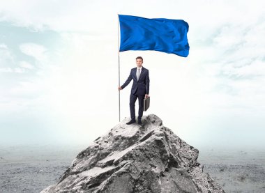 İşadamı üst tarafındaki bir bayrak tutan dağ