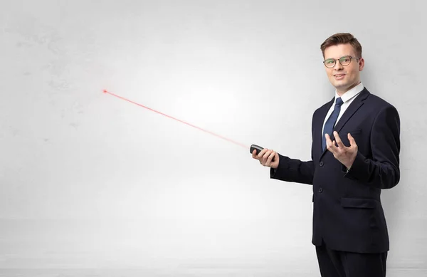 Uomo d'affari con puntatore laser e parete bianca copyspace — Foto Stock