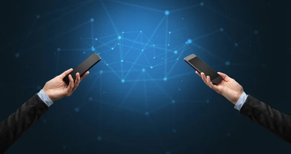 Primer plano de dos manos sosteniendo teléfonos inteligentes — Foto de Stock