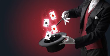 Magician making trick with wand and playing cards clipart