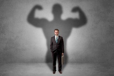 Businessman with muscular shade behind his back clipart